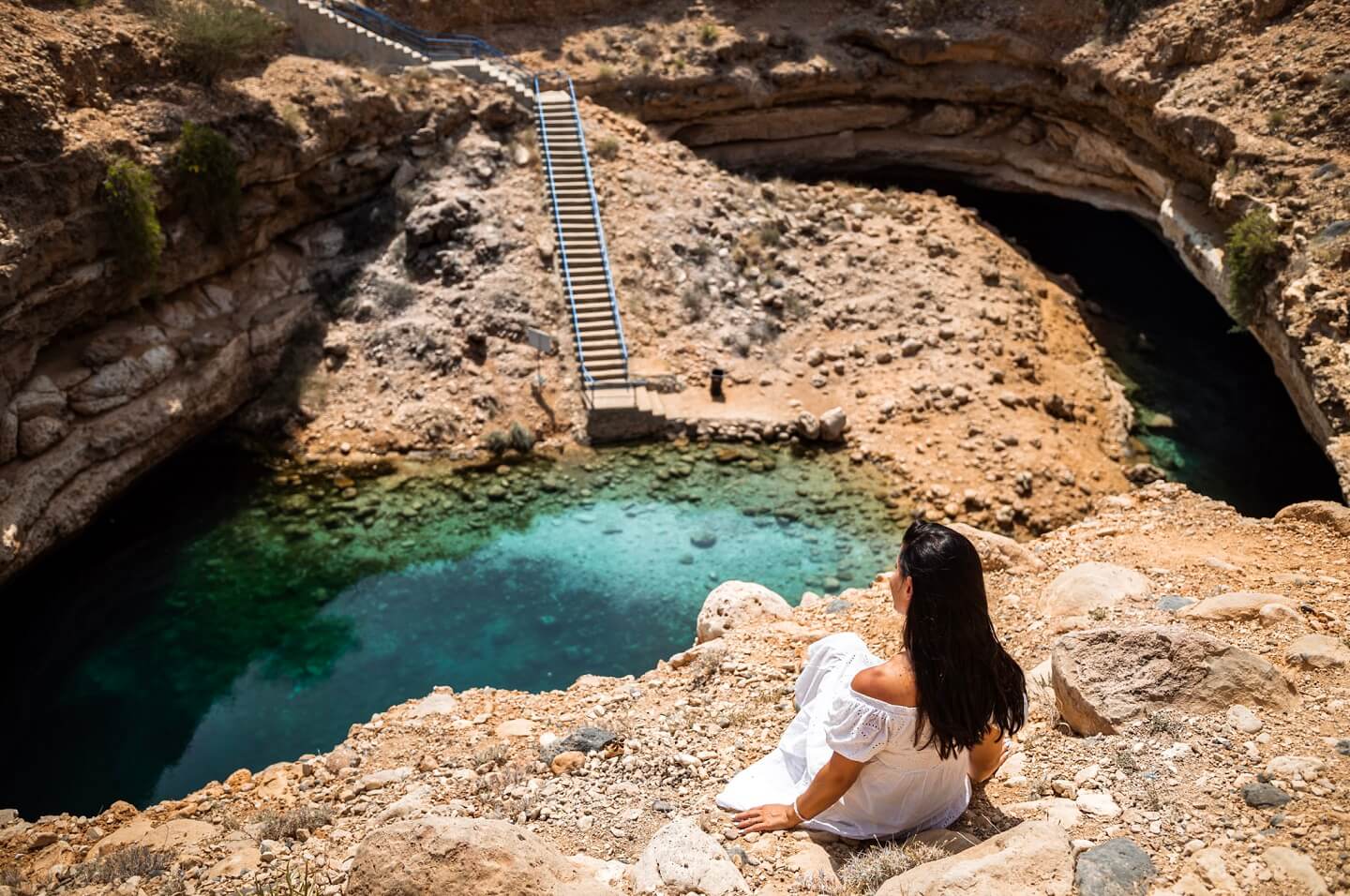 Girl sitting on top of Bimmah Sinkhole in Oman