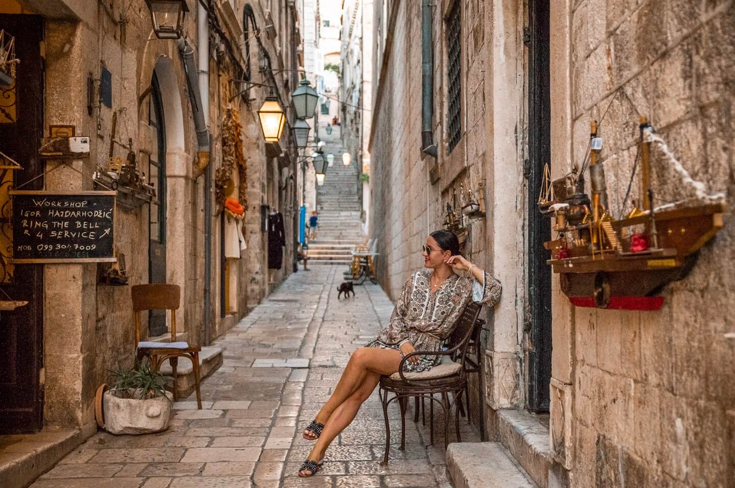 Girls sitting in front of restaurant in small alley in Dubrovnik