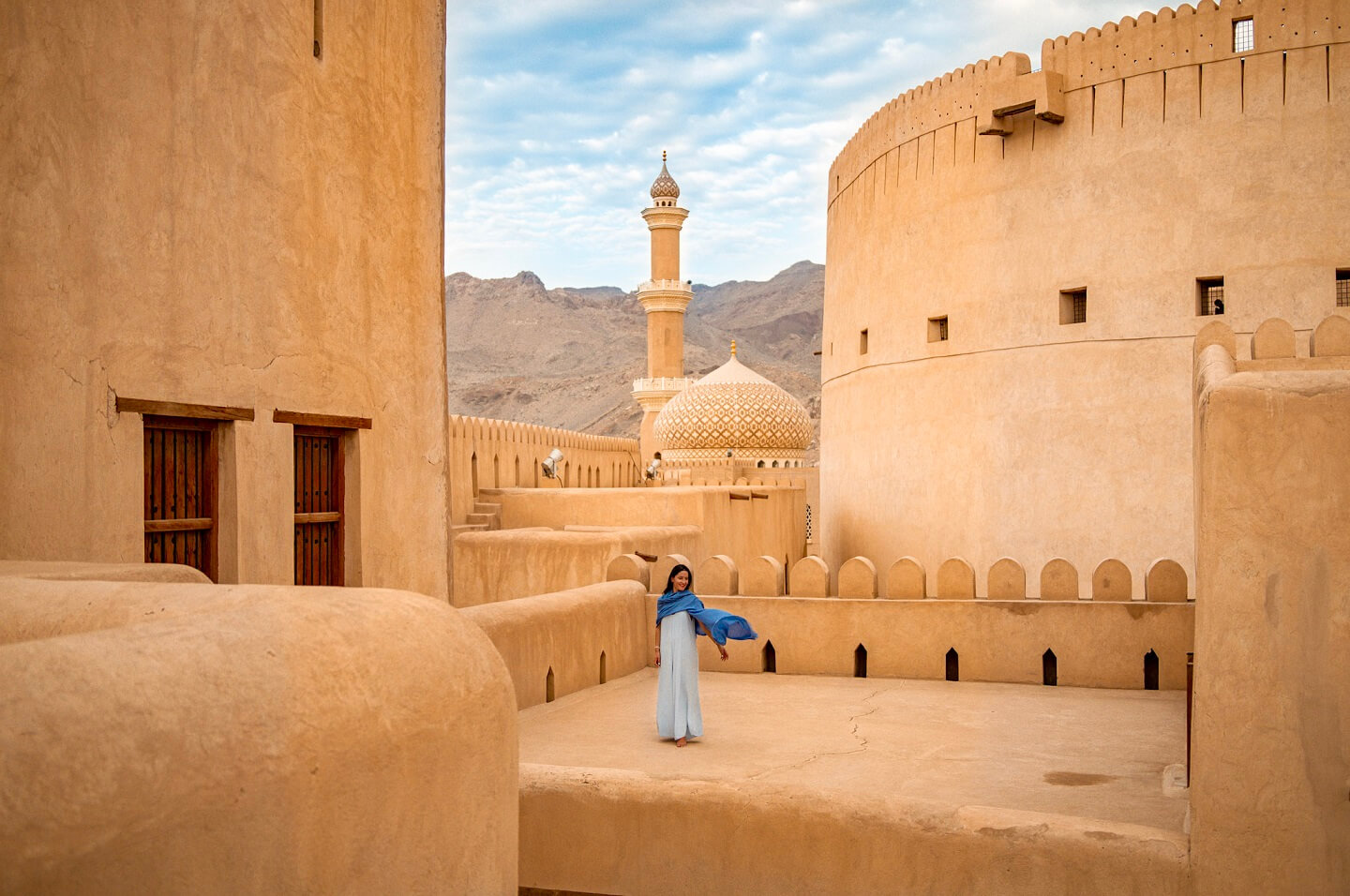 Girl in blue dress poses in the old castle