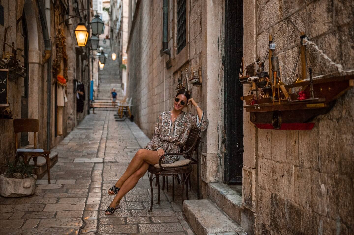 Girl posing on the chair in old alley 