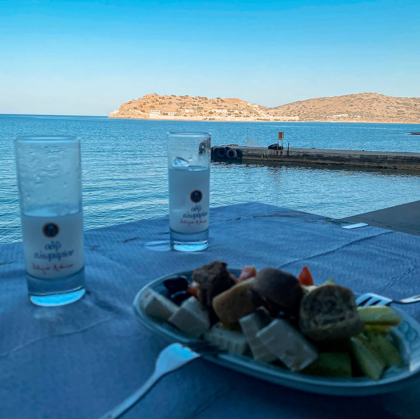 Ouzo and meze at the restaurant in Plaka Crete with Spinalonga island view
