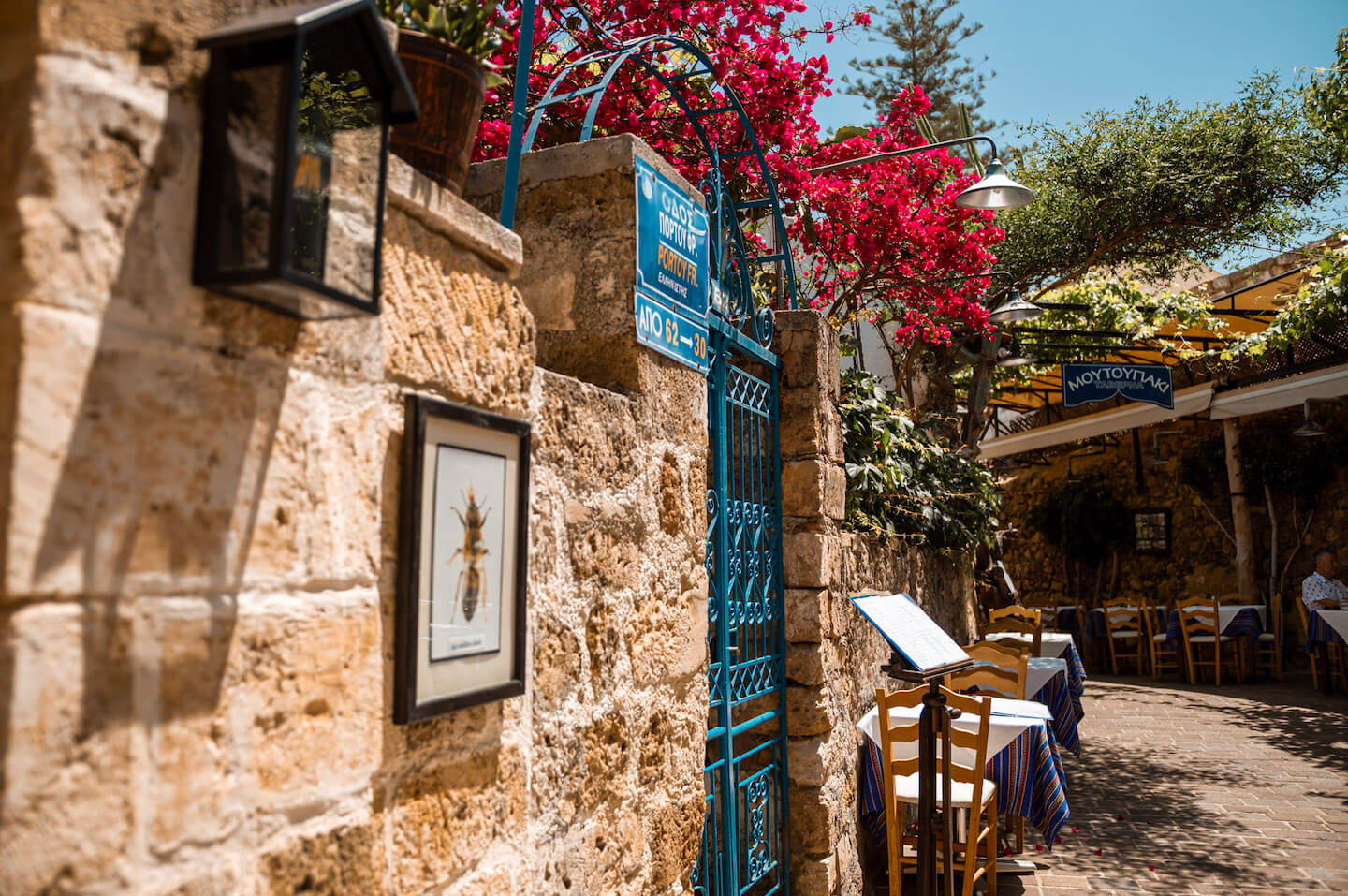 Picturesque alley in Chania Crete with red flowers