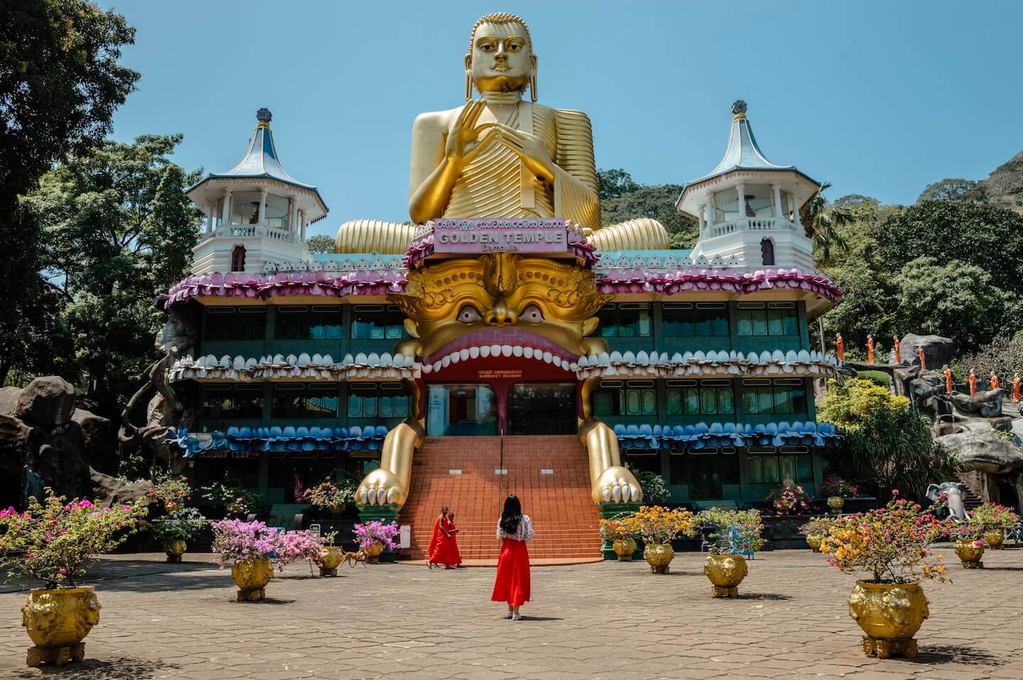 Stella weraning red dress standing in from of Golden Buddha temple
